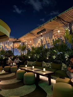 people are sitting at tables under umbrellas on the roof top terrace in an outdoor restaurant