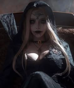 a woman with makeup on her face and chest is sitting in a chair wearing a black outfit