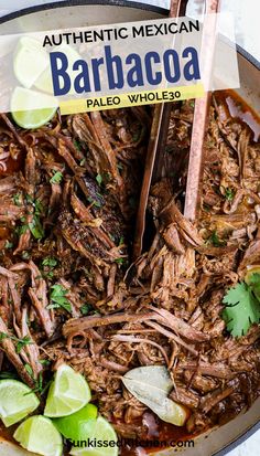 a pot filled with shredded meat and garnished with cilantro, lime wedges and parsley