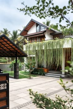 an outdoor area with plants and trees in front of a house that is surrounded by greenery