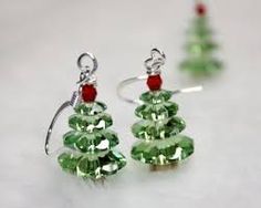 two green christmas tree shaped earrings with red beads and silver earwires on a white surface