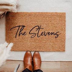 a person standing in front of a door mat that says the stevenss