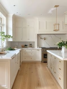 a large kitchen with white cabinets and wood flooring on the walls, along with an island in the middle