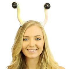 a woman with long blonde hair and horns on her head smiles at the camera while standing in front of a white background