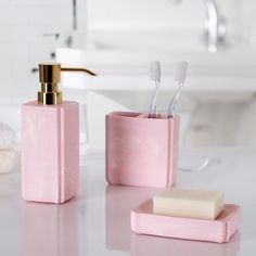 two pink soap dispensers sitting on top of a bathroom counter