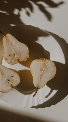 three pieces of fruit sitting on top of a white plate