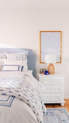 a bedroom with white furniture and blue accents