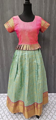 Introducing our stunning Pattu Pavadai - a South Indian traditional lehenga set - in a size 38, perfect for girls. Measuring 18 inches in blouse length, this set features a beautiful range of colorful fabrics and designer lehengas to choose from. Made from high-quality pattu material, our kids lehenga choli set is both comfortable and elegant, ensuring your young lady looks her best for any occasion. Shop our range of designer lehengas for girls now to add a touch of traditional charm to your child's wardrobe. Fitted Anarkali Set With Tilla For Eid, Fitted Tilla Anarkali Set For Eid, Eid Fitted Anarkali Set With Tilla Details, Diwali Semi-stitched Skirt Set With Pallu, Diwali Semi-stitched Pallu Skirt Set, Fitted Anarkali Skirt Set For Diwali, Anarkali Art Silk Skirt Set For Diwali, Art Silk Saree Skirt Set With Pallu, Art Silk Saree Skirt Set With Pallu Detail