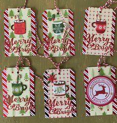 four christmas gift tags with coffee mugs and snowflakes hanging from strings on a table