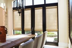 a dining room table with chairs and a vase on it