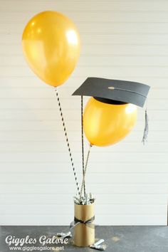 a graduation cap and tasseled balloons in a vase