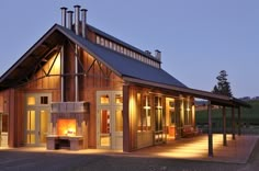 a large wooden building with lots of windows and lights on it's sides, lit up at night