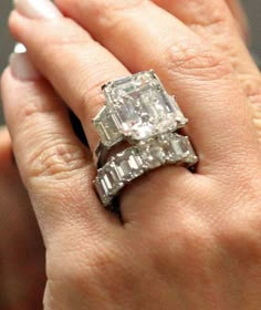 a woman's engagement ring with two baguettes on top of her finger