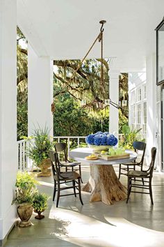 an outdoor dining area with chairs, table and potted plants