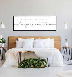 a bed with white sheets and pillows on top of it in a bedroom next to two tables