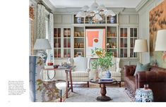 a living room filled with furniture and lots of bookshelves on top of it