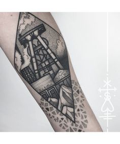 a black and white photo of a lighthouse tattoo on the arm