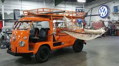 an orange vehicle with a hammock attached to the front parked in a garage