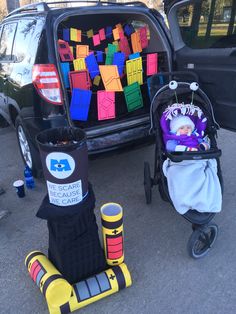 two strollers are parked in front of a car decorated with colorful blocks and decorations