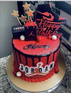 a red and black birthday cake with stars on top is sitting on a countertop