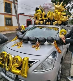 a silver car with balloons and numbers on it