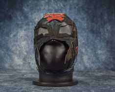 a helmet with an orange and black design on the side is shown in front of a gray background