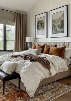 a large bed sitting in a bedroom next to two framed pictures on the wall above it