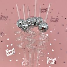 there are three silver disco balls on top of each other in a clear glass vase