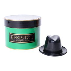 a black and green hat sitting next to a canister with the word resttol on it