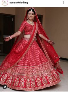 a woman in a red lehenga is posing for the camera