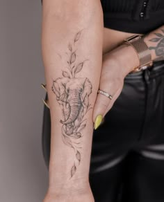 a woman's arm with an elephant and flower tattoo on the left side of her body