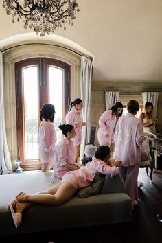 a group of women in pink dressing gowns getting ready to go into the bathroom