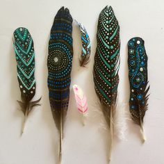 four feathers with blue and black designs on them