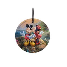 a mickey mouse ornament hanging from a cord on a white background with an ocean scene in the background