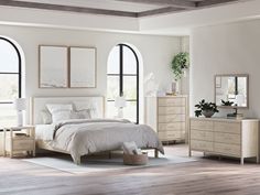 a white bedroom with arched windows and wooden flooring, along with a bed in the center