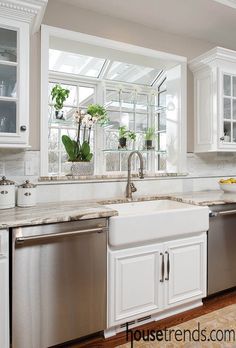 a kitchen with white cabinets and stainless steel dishwasher in the center, window over the sink