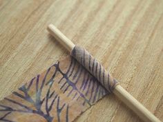 a piece of cloth with a wooden stick sticking out of it sitting on a table