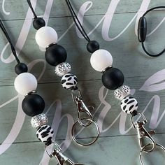 two black and white beaded lanyards on a wooden background with the words hello kitty