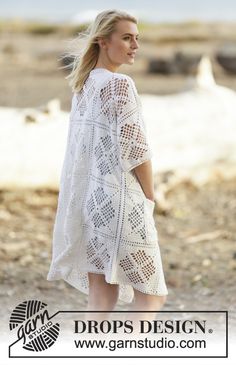 a woman standing on the beach wearing a white crochet dress