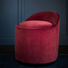 a large red chair sitting on top of a blue carpet next to a wooden floor