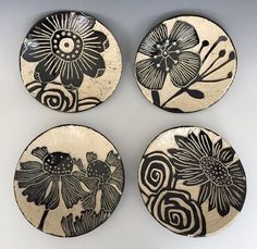 four black and white plates with flowers on them