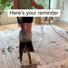 a woman is using a vacuum to clean the carpet in her living room with an ad that reads here's your reminder