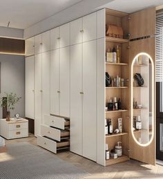 a bedroom with white furniture and wooden flooring next to a large mirror on the wall