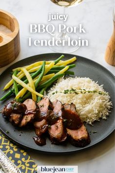 a plate with meat, rice and green beans on it next to a glass of wine