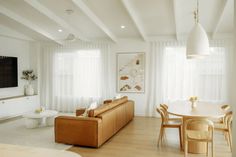 a living room filled with furniture and a flat screen tv mounted on the wall next to a dining table