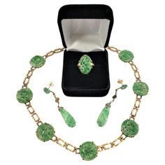 This necklace, ring and earring set is signed by an unknown maker, and presumed to have originated from China and date to approximately 1920 and done in a period Chinese Export style. The set is composed of 14 Karat yellow gold with carved light green jade medallions with carved flowers and leaves on each respectively. The clasp of the necklace is marked "14K" and "WL", but we were not able to identify this maker. Please note the ring is size 5. Chinese Jewelry Traditional, Carved Flowers, Antique Jade, Chinese Jewelry, Carved Jade, China Jewelry, Chinese Export, Necklace Ring, Jade Earrings