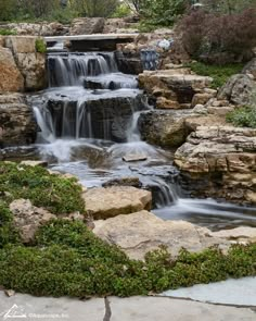 there is a waterfall in the middle of this garden