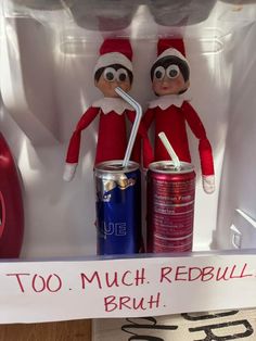 two elfs are sitting next to each other in an open refrigerator with soda cans