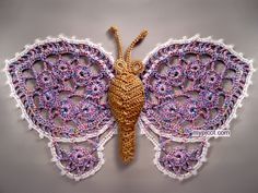 a crocheted butterfly is shown on the wall