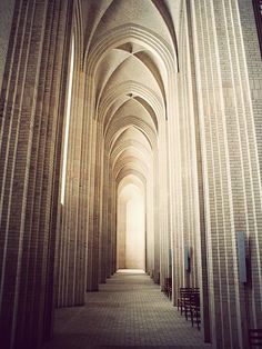 an image of a very long hallway in the middle of a building that has columns on both sides